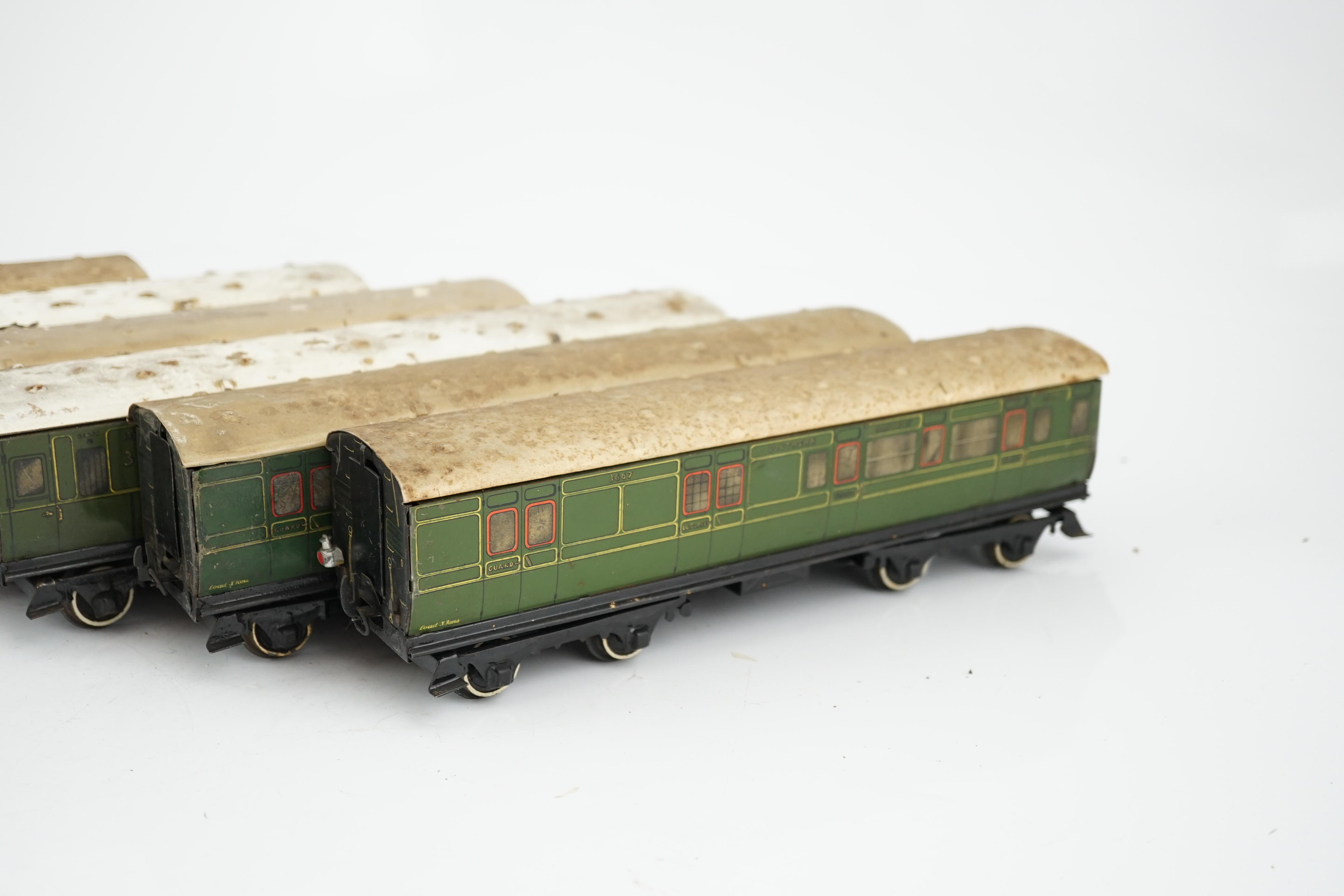 Six Hornby 0 gauge tinplate No.2 coaches in Southern Railway livery, one coach adapted to a driving unit with clockwork motor and replacement bogie